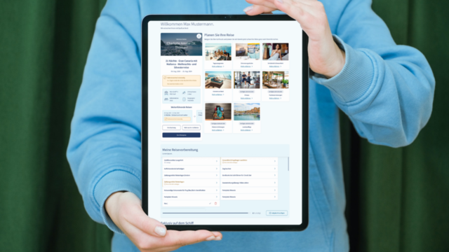 Person hält Tablet mit Reisebuchungsseite in blauer Jacke.