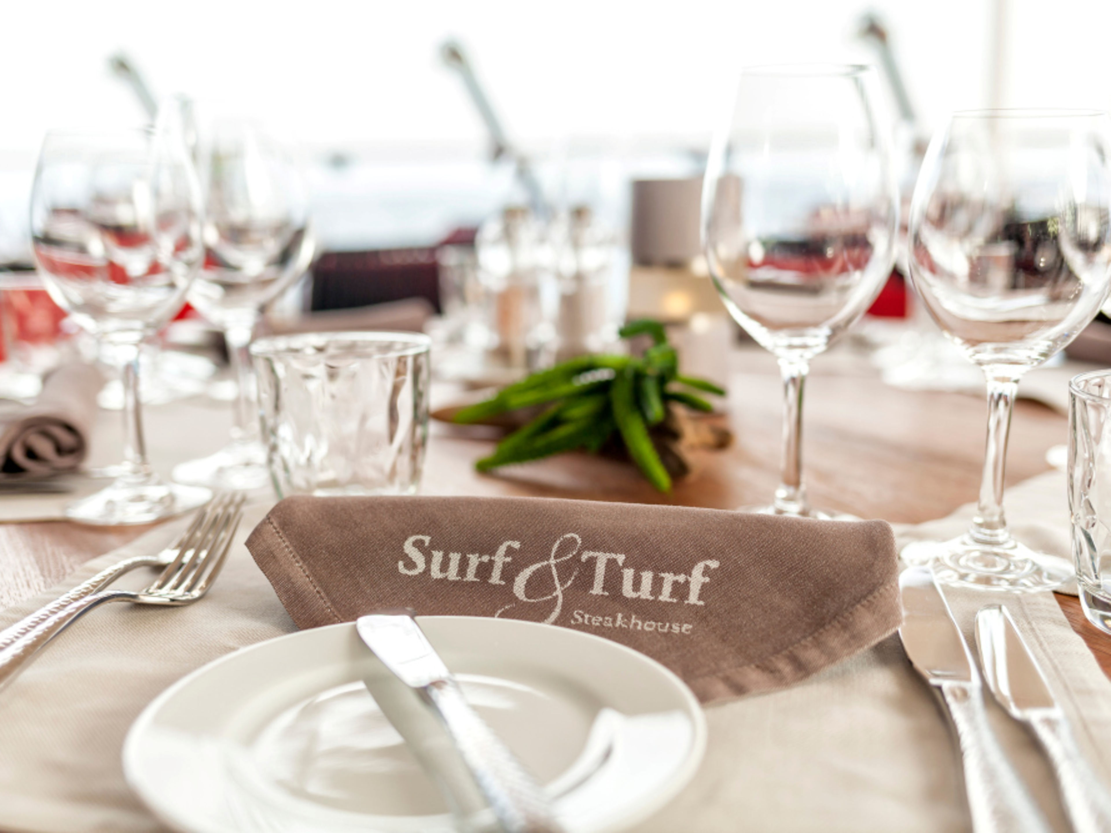 Gedeckter Tisch im Surf & Turf Steakhouse mit Gläsern und Besteck. Gedeckter Tisch im Surf & Turf Steakhouse mit Gläsern und Besteck.