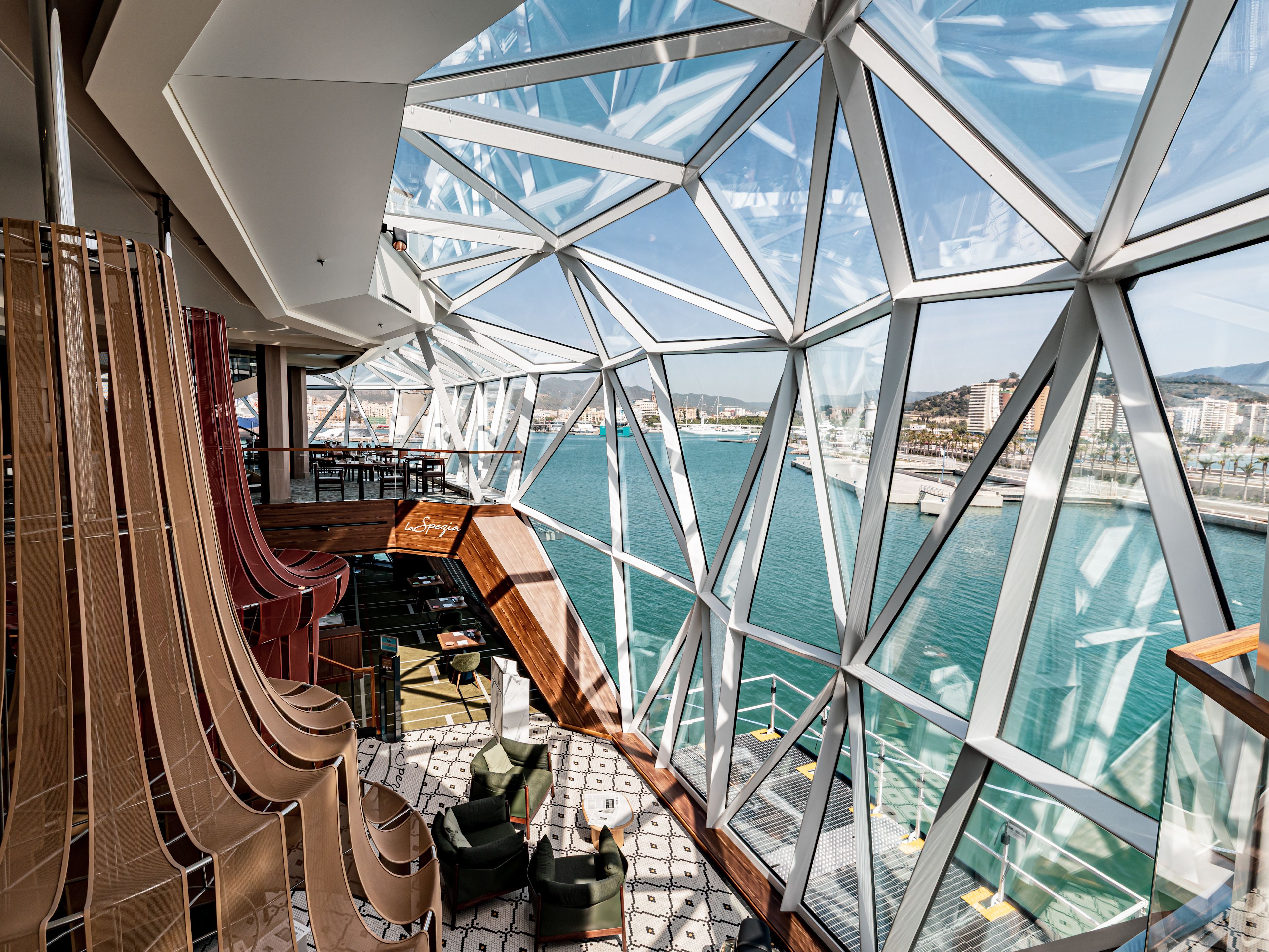 Mein Schiff 7 Modernes Kreuzfahrtschiff-Interieur mit Panoramafenstern, Blick auf Hafen und Meer.