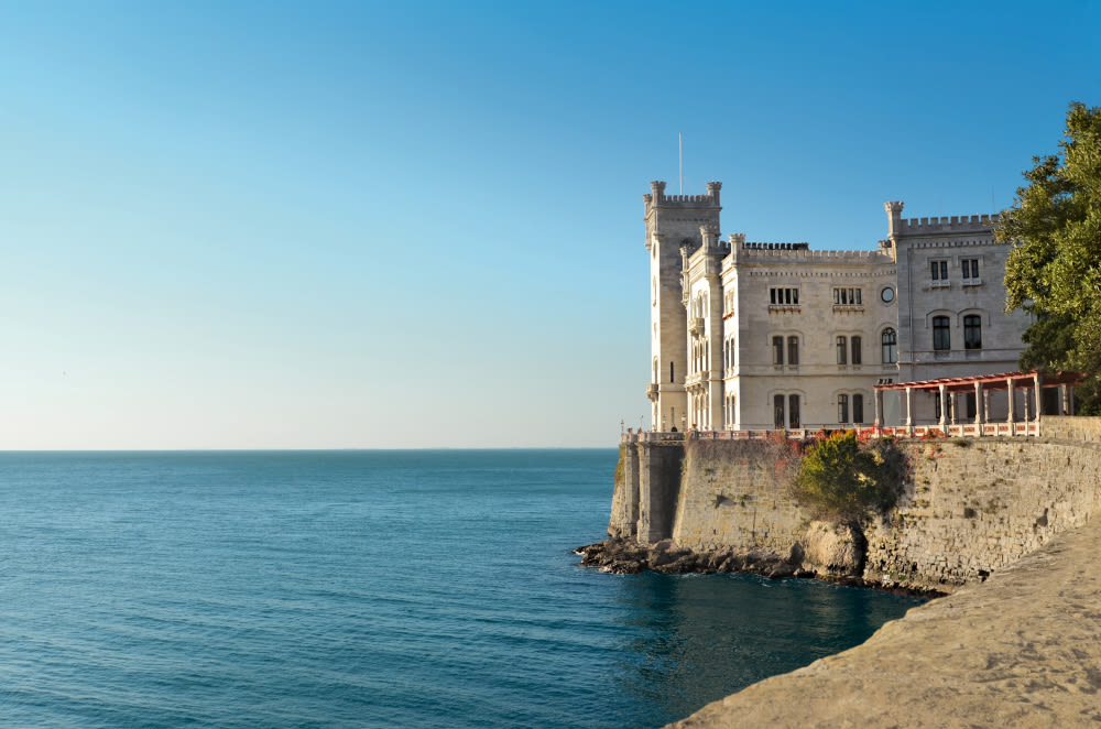 Schloss Miramare an der Küste bei klarem Himmel.