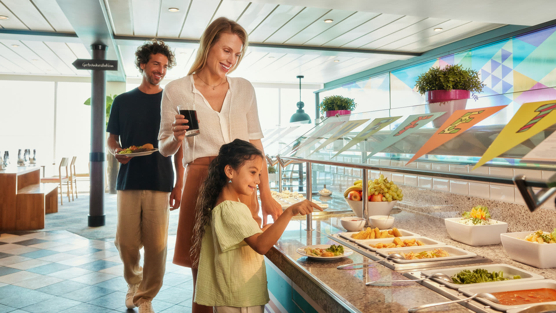 Familie am Buffet auf Kreuzfahrtschiff der Mein Schiff® Flotte, fröhlich essend.
