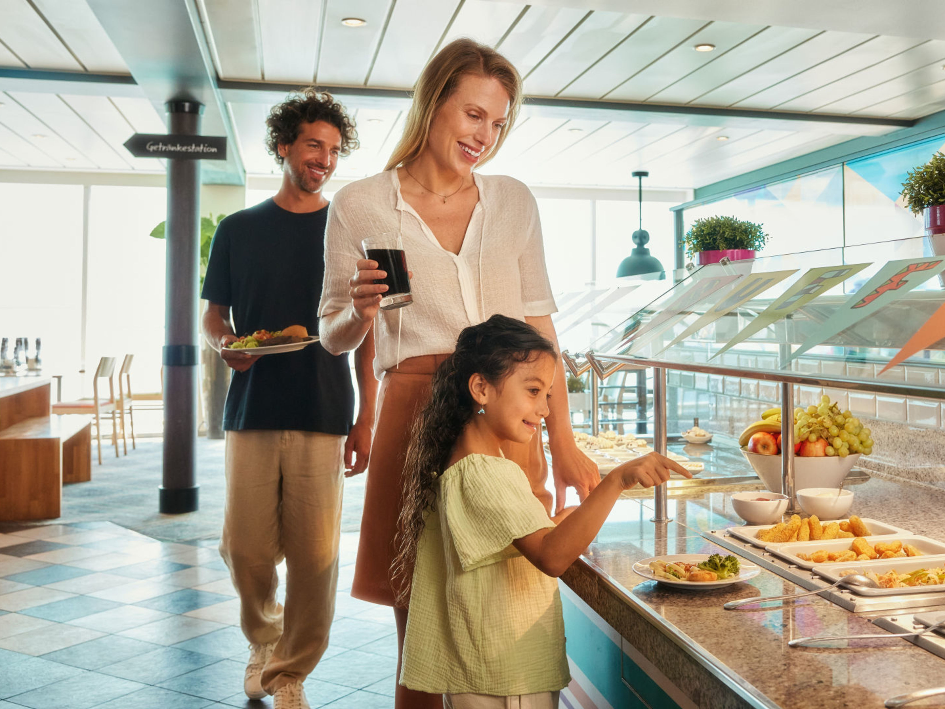 Eltern mit Kind am Kinderbuffet Familie am Buffet auf Kreuzfahrtschiff der Mein Schiff® Flotte, fröhlich essend.