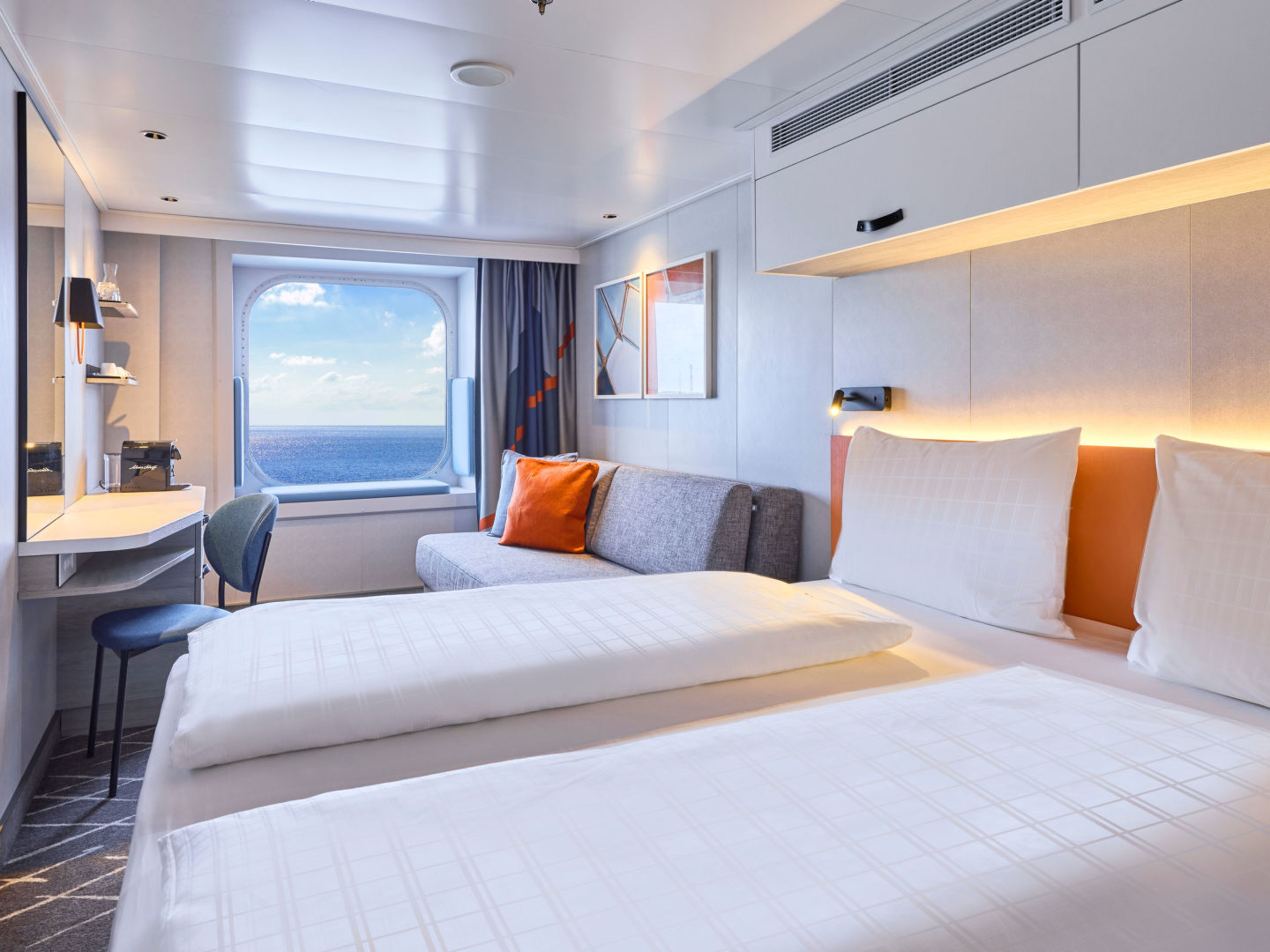 Helles Kreuzfahrtschiff-Kabine mit Meerblick, Doppelbett, Sofa, Schreibtisch. Helles Kreuzfahrtschiff-Kabine mit Meerblick, Doppelbett, Sofa, Schreibtisch.