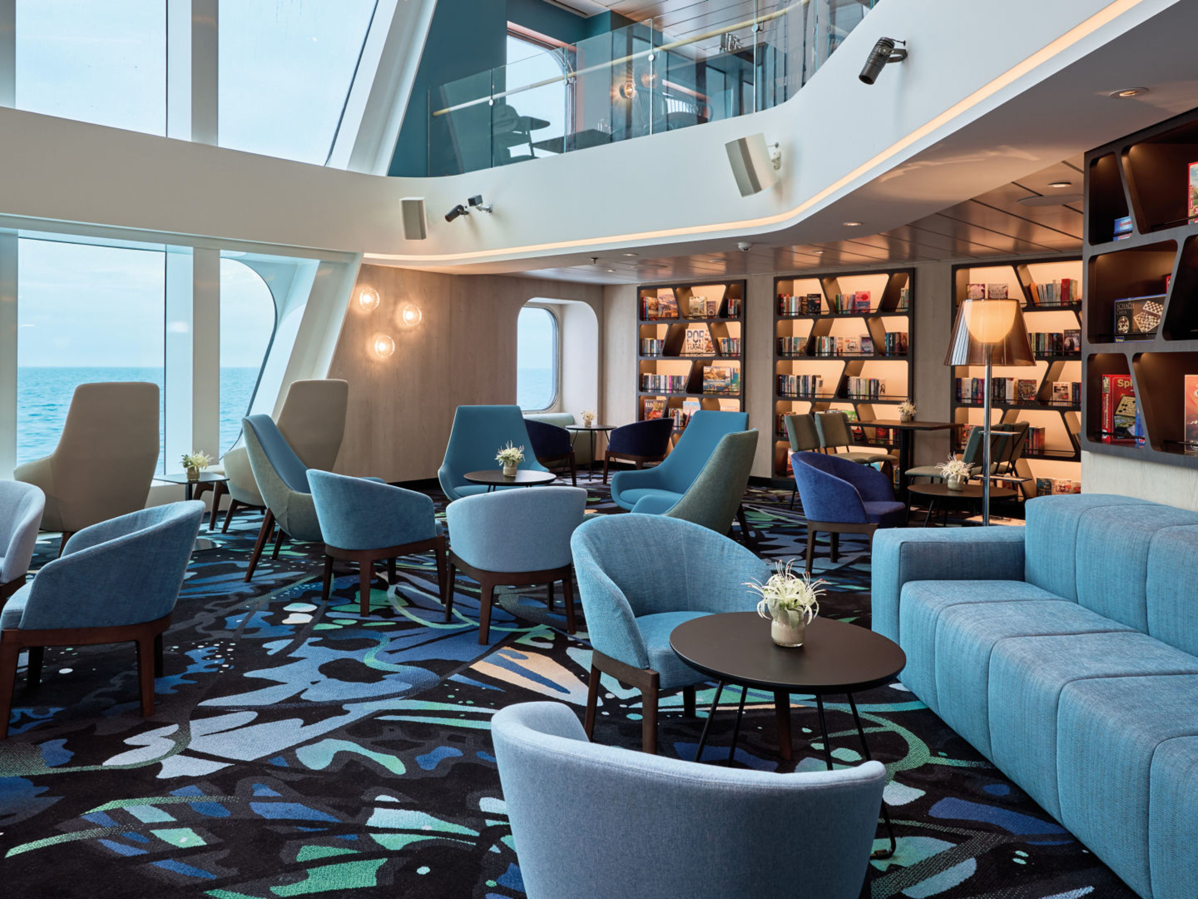 Moderne Lounge auf Kreuzfahrtschiff mit blauen Sesseln und Meerblick. Moderne Lounge auf Kreuzfahrtschiff mit blauen Sesseln und Meerblick.