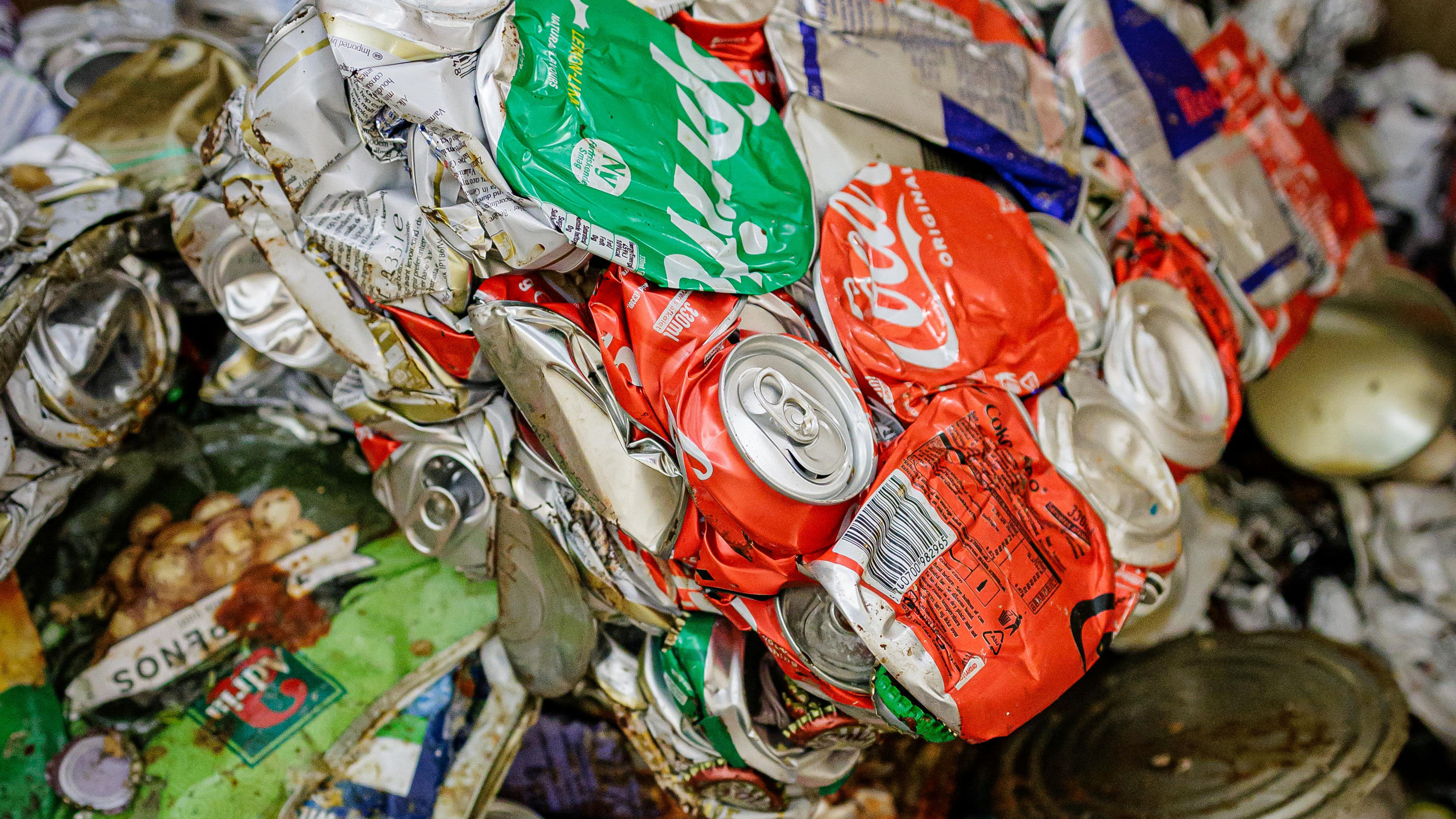 Zerdrückte Getränkedosen in verschiedenen Farben, Recyclingmaterial.