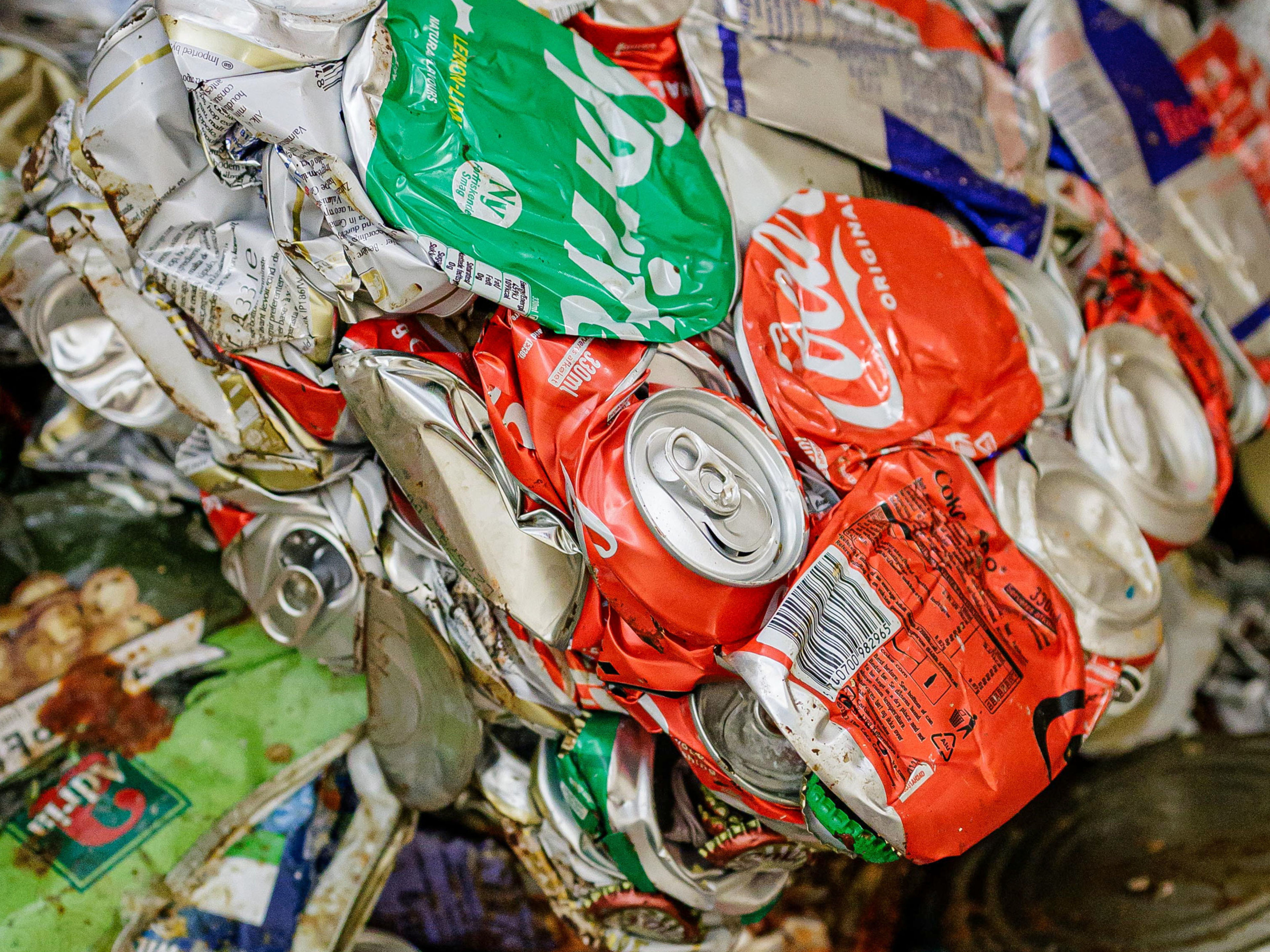 Nachhaltigkeit - Abfallmanagement - Aluminiumdosen Zerdrückte Getränkedosen in verschiedenen Farben, Recyclingmaterial.