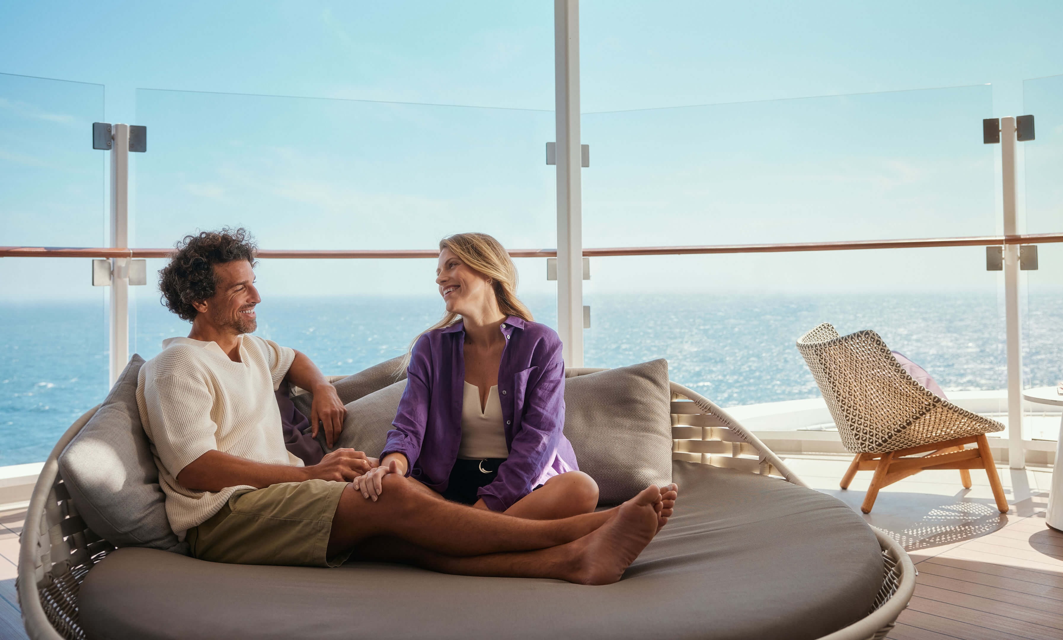 Paar entspannt auf Kreuzfahrtschiff der Mein Schiff® Flotte, Meerblick.