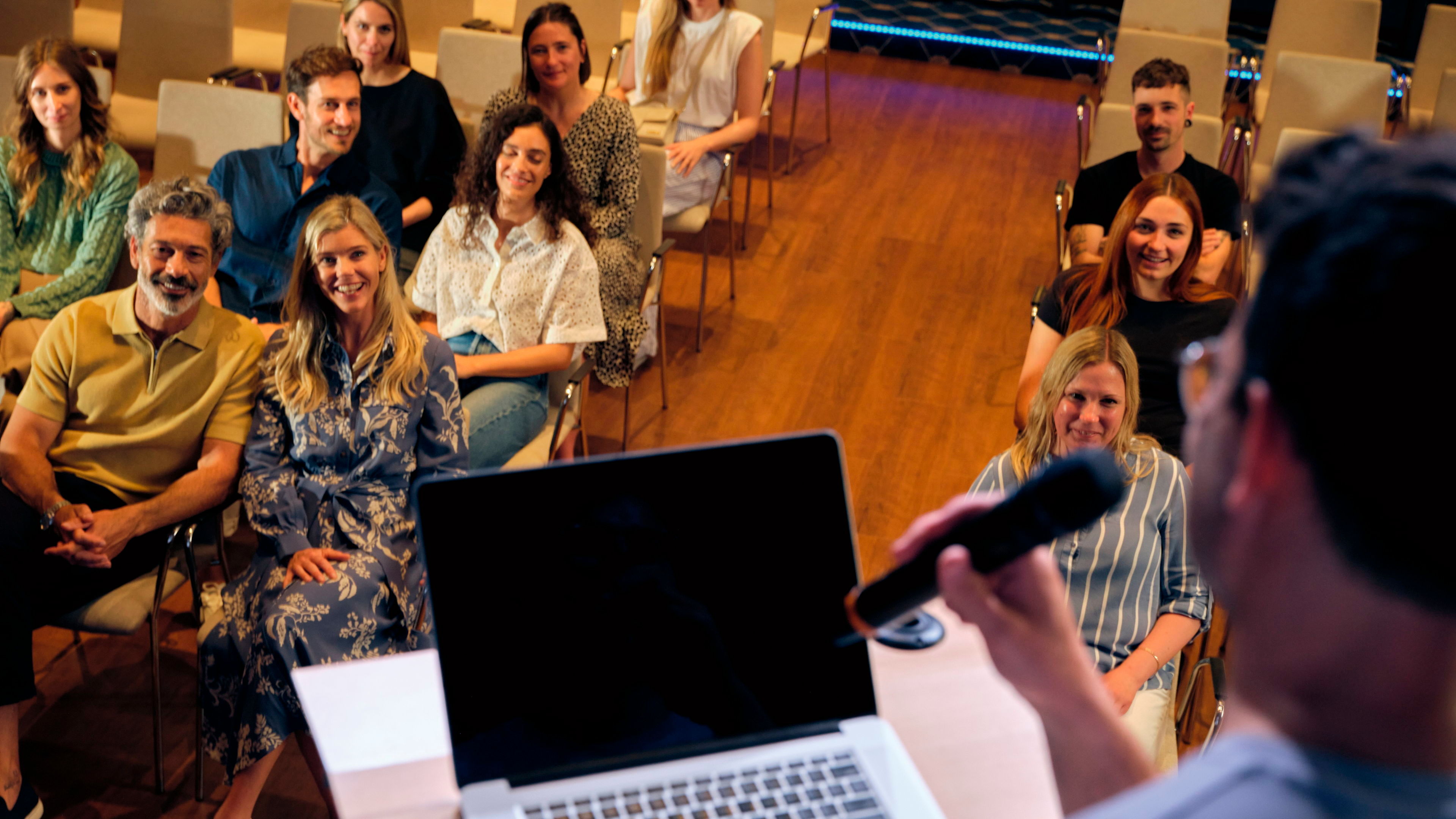 Konferenzraum Person spricht vor lächelndem Publikum in einem Konferenzraum.