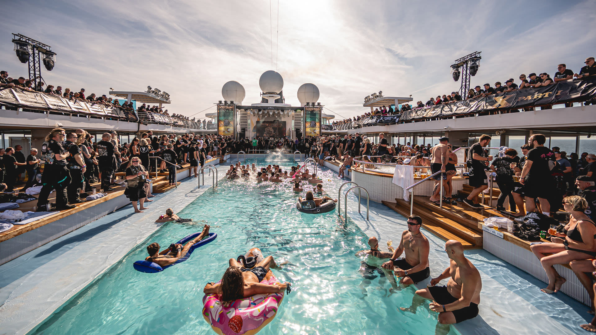 Menschen feiern am Pool auf einem Kreuzfahrtschiff der Mein Schiff® Flotte.