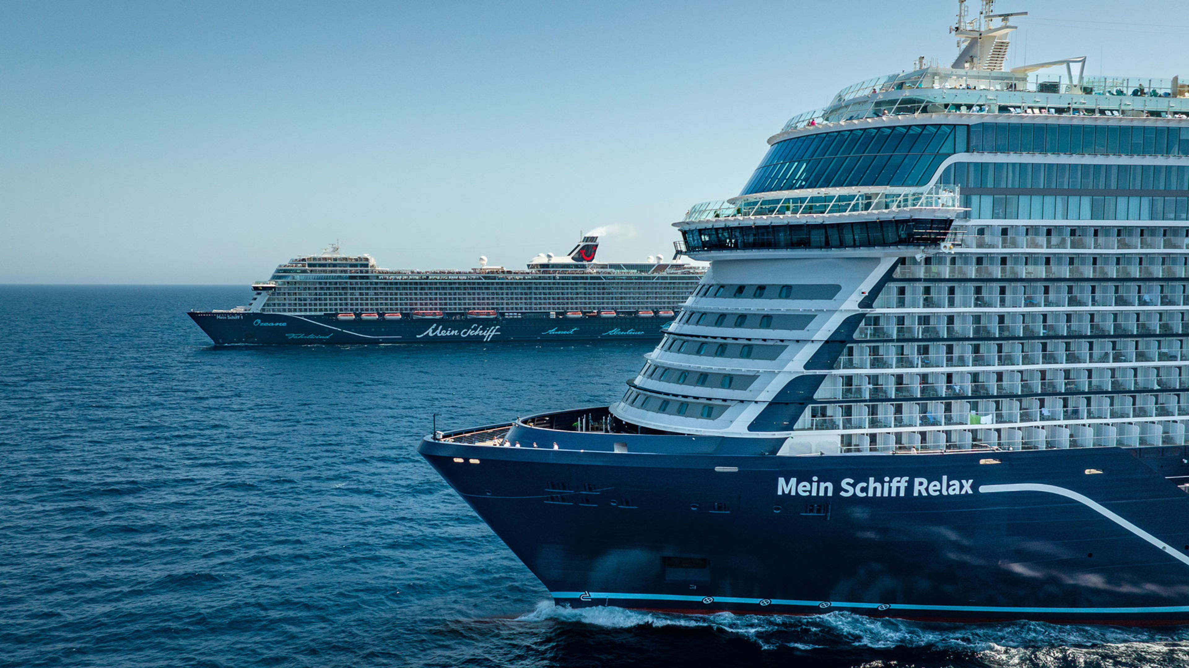 Flottentreffen Mein Schiff Relax und Mein Schiff 1 Zwei Kreuzfahrtschiffe der Mein Schiff® Flotte auf offenem Meer.