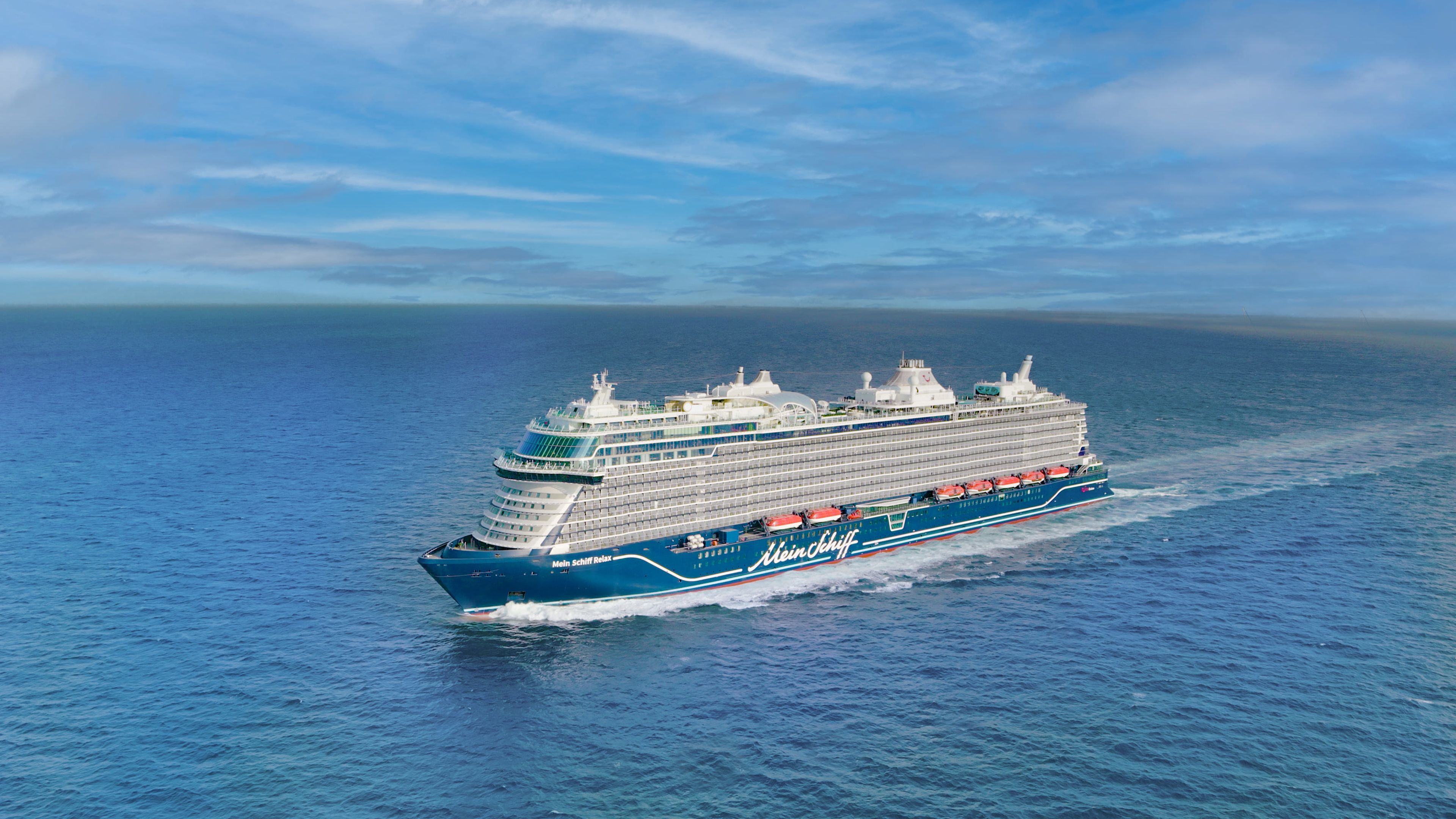 Kreuzfahrtschiff der Mein Schiff® Flotte auf offenem Meer unter blauem Himmel. Kreuzfahrtschiff der Mein Schiff® Flotte auf offenem Meer unter blauem Himmel.