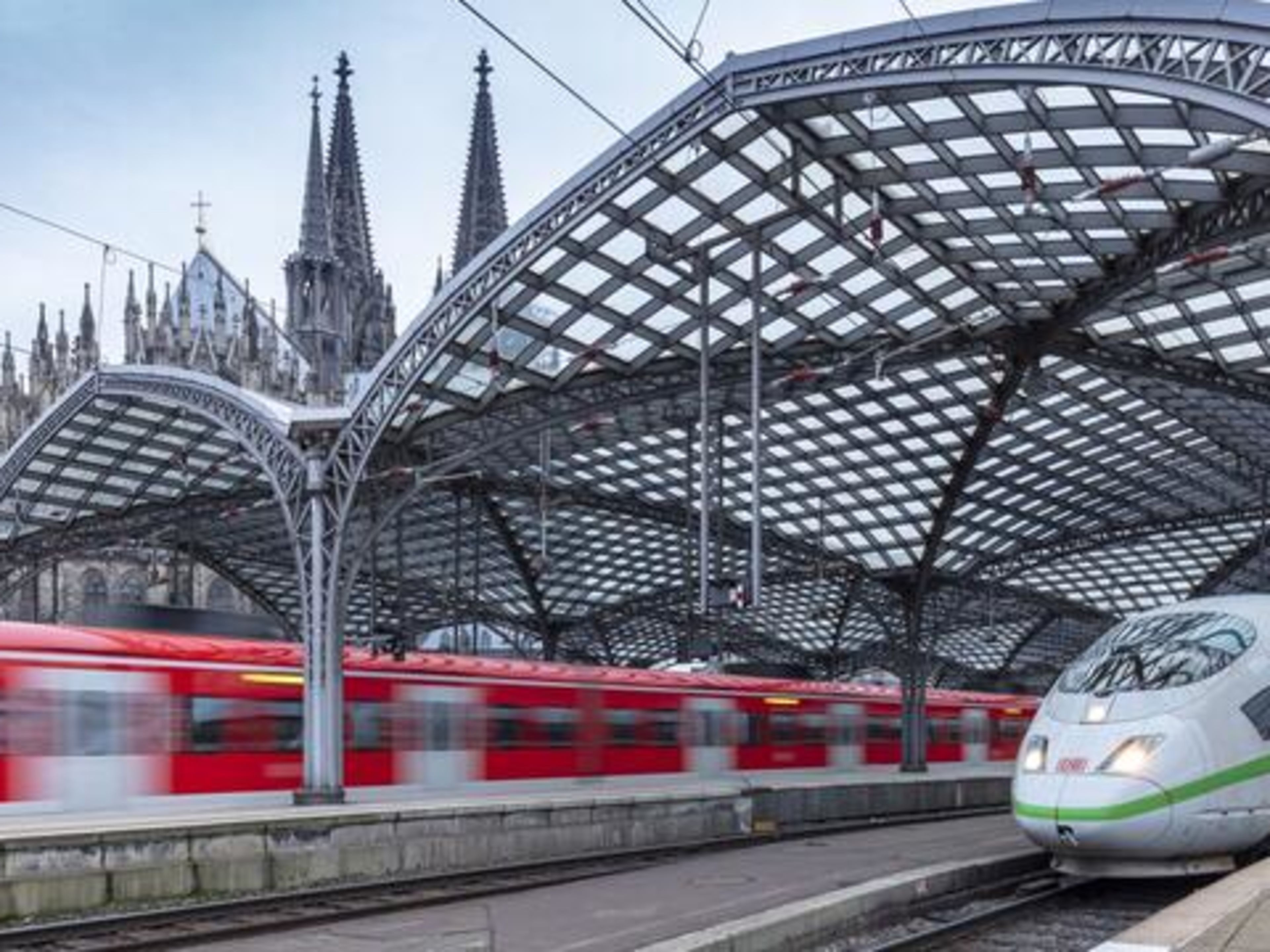 Bahnhof Kölner Dom, ICE-Zug und rote Regionalbahn am Bahnhof.