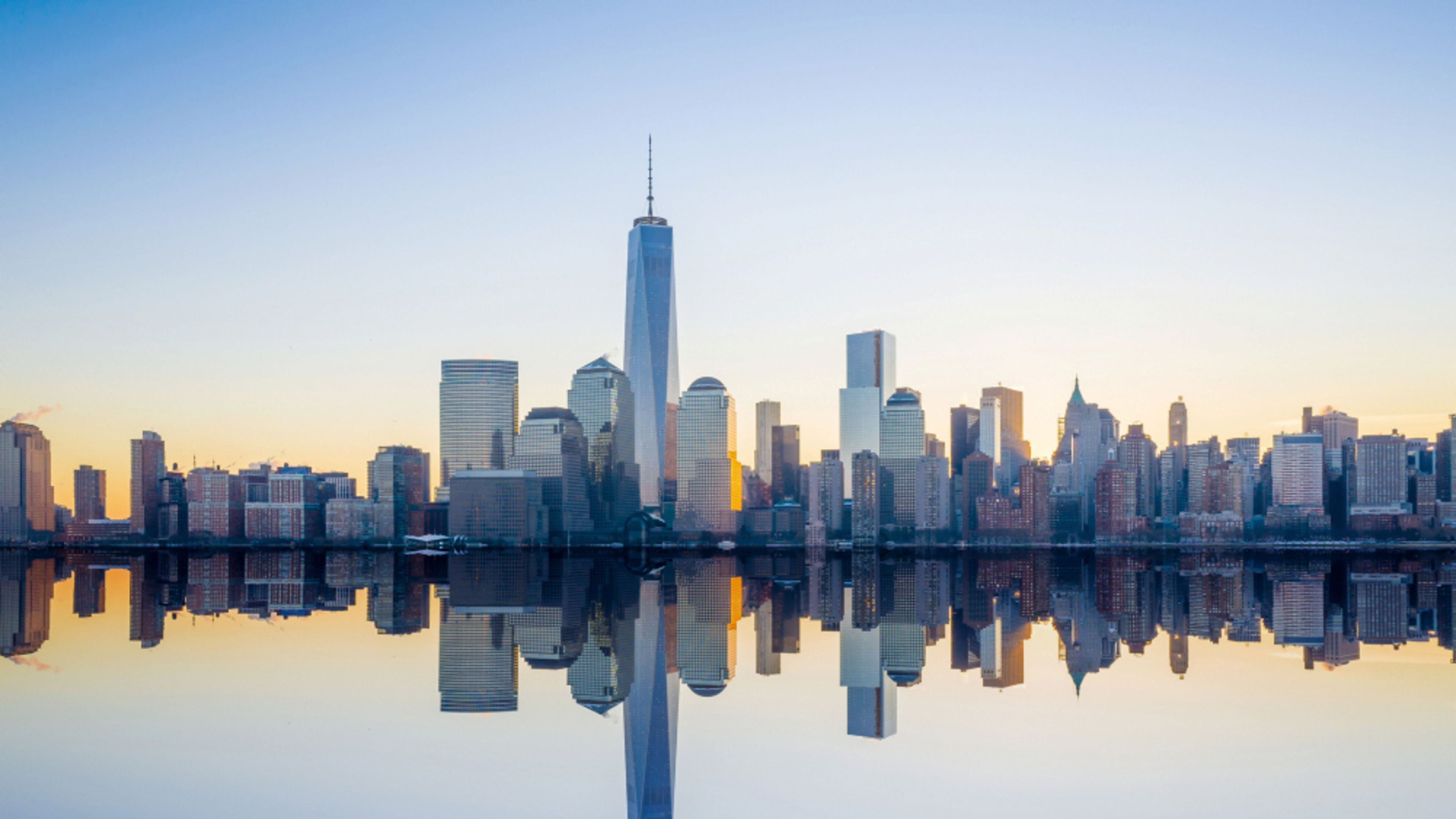New York New York Skyline bei Sonnenaufgang, Spiegelung im Wasser.