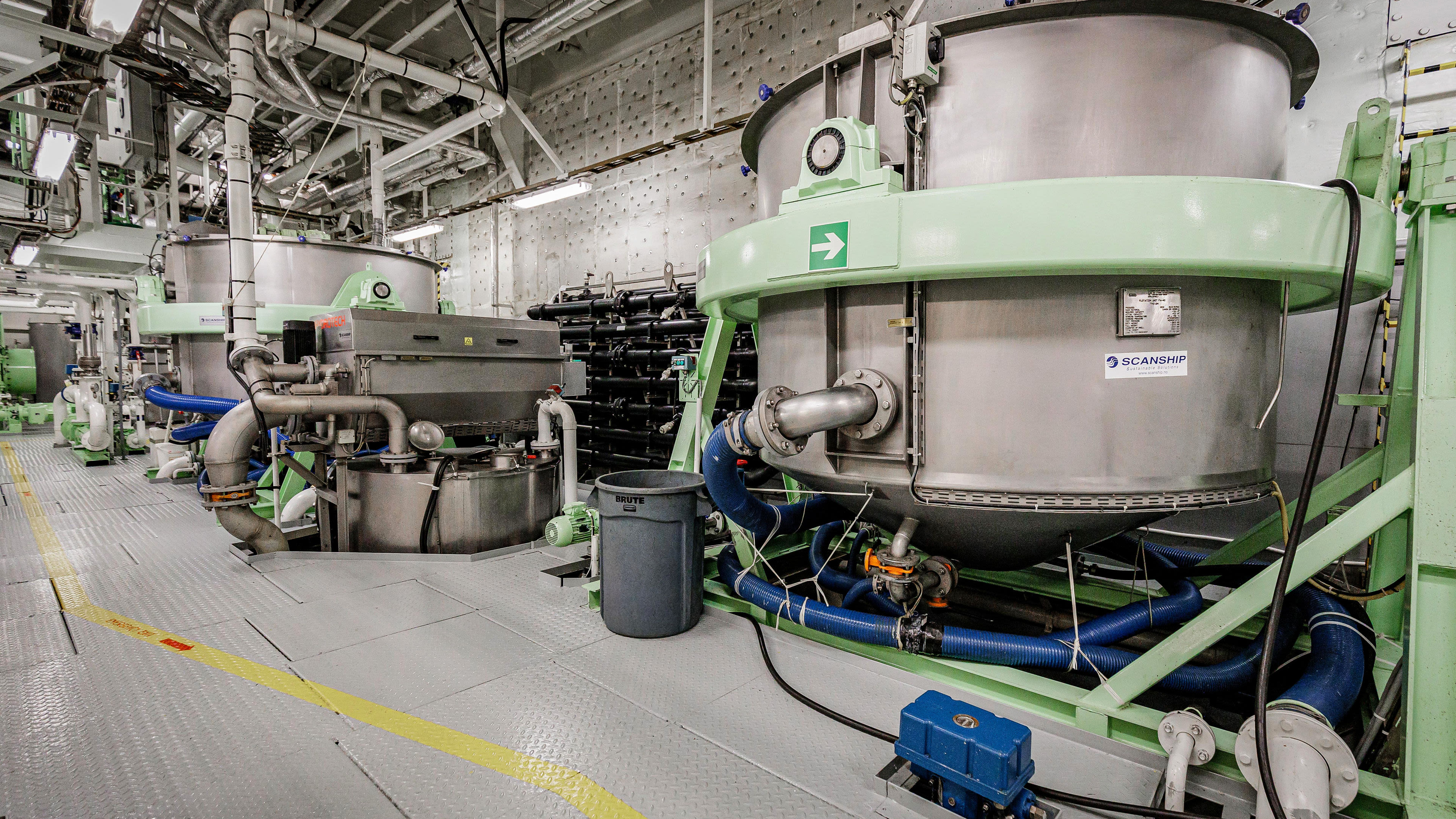 Industrielle Maschinen mit Rohren und Tanks in einem technischen Raum.