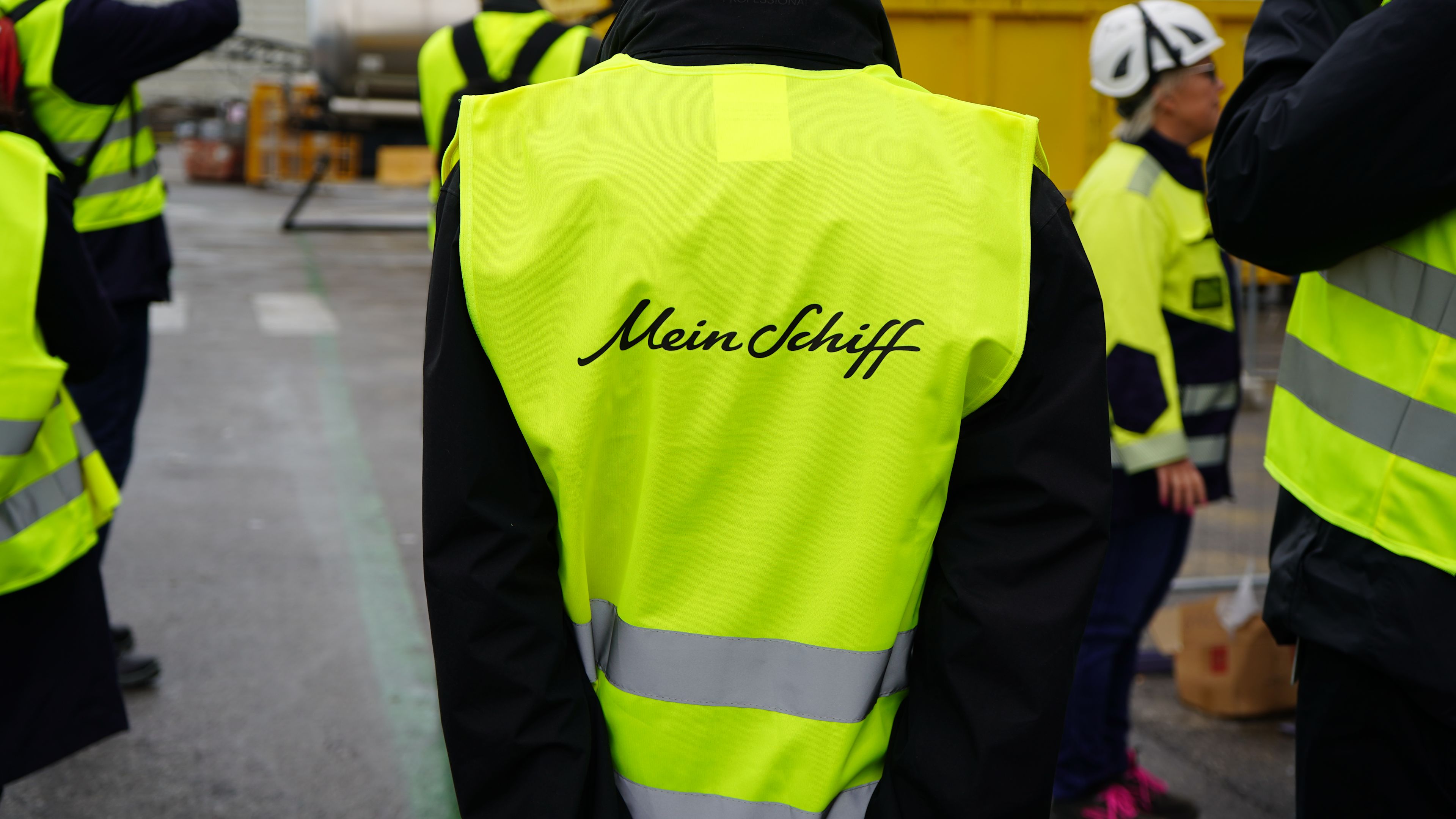 Person in gelber Weste mit "Mein Schiff" Schriftzug.
