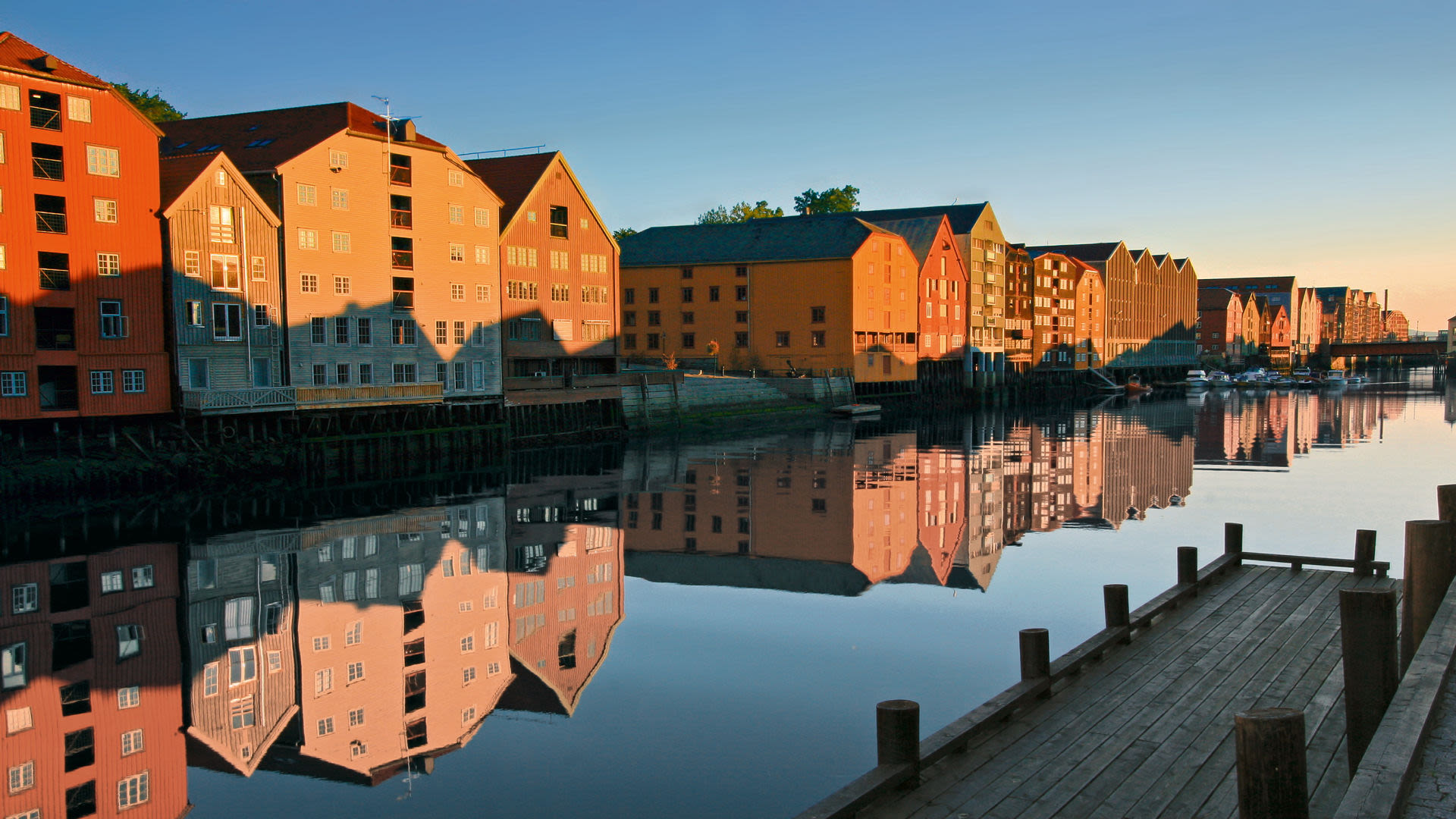 Bunte Lagerhäuser spiegeln sich im Fluss in Trondheim. Bunte Lagerhäuser spiegeln sich im Fluss in Trondheim.