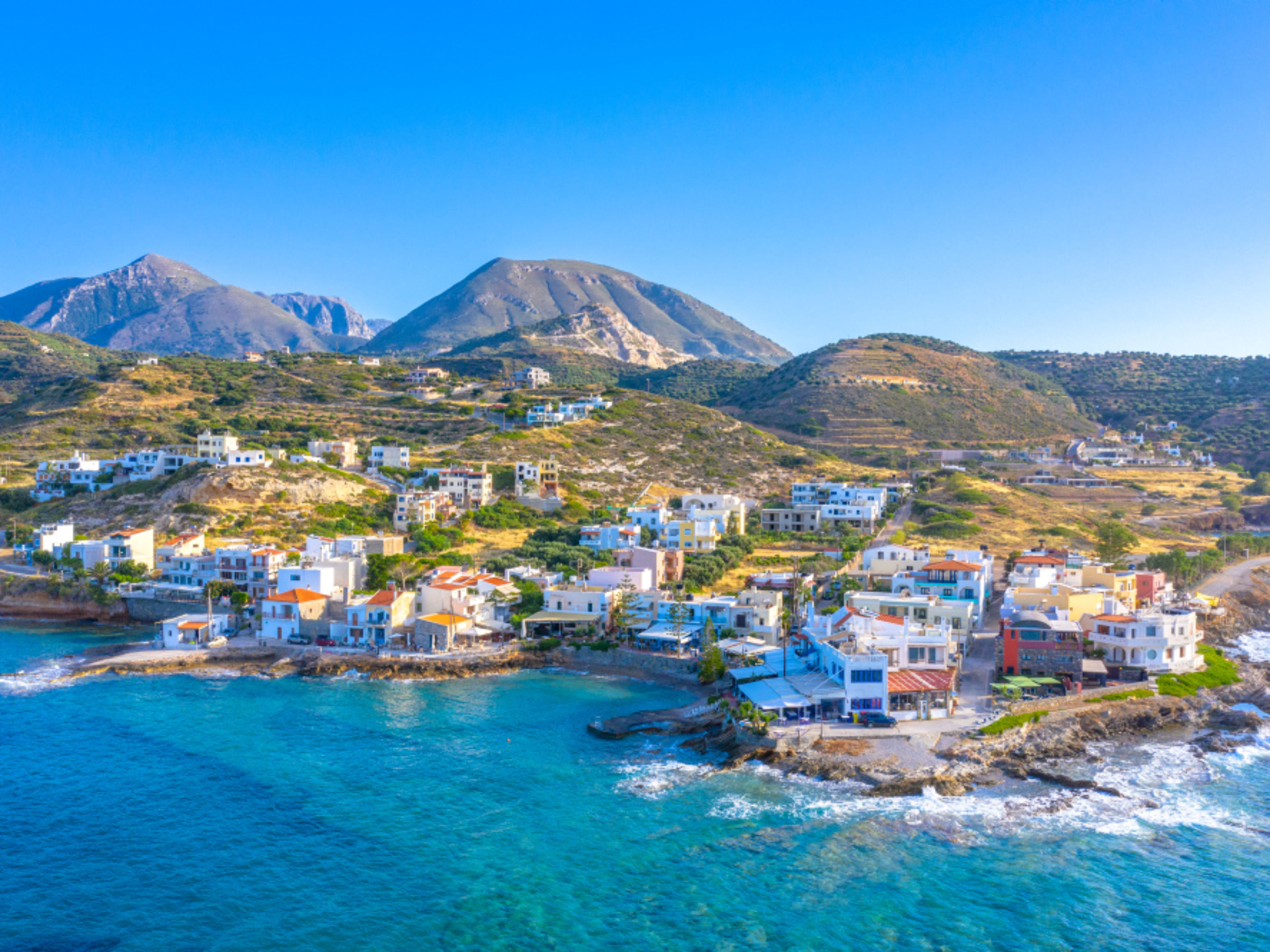 Mittelmeer Kreta Küstenstadt auf Kreta mit bunten Häusern und Bergen im Hintergrund.
