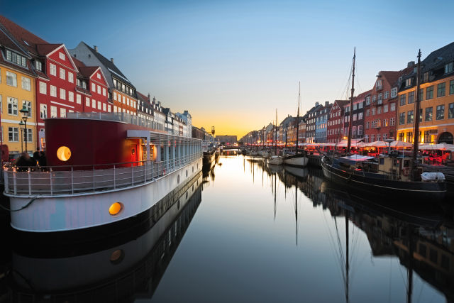 Nyhavn, Kopenhagen bei Sonnenuntergang, bunte Häuser, ruhiger Kanal.