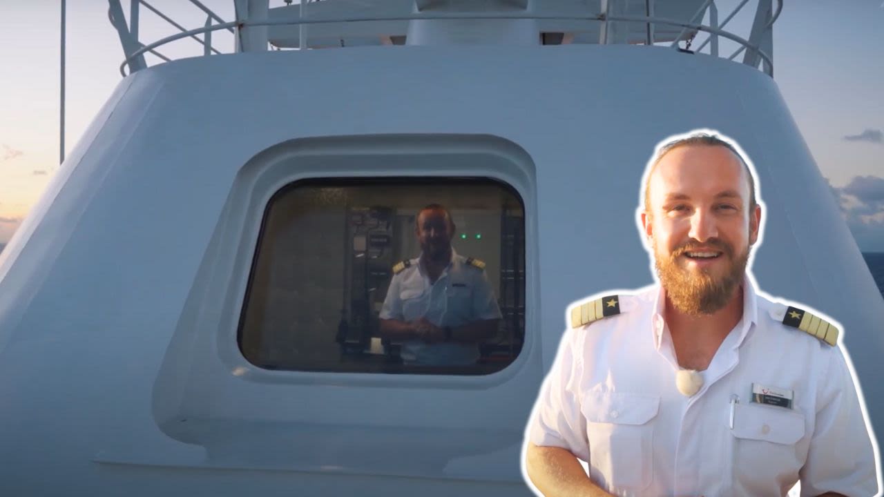 Mann in weißer Uniform vor Kreuzfahrtschiff der Mein Schiff® Flotte.
