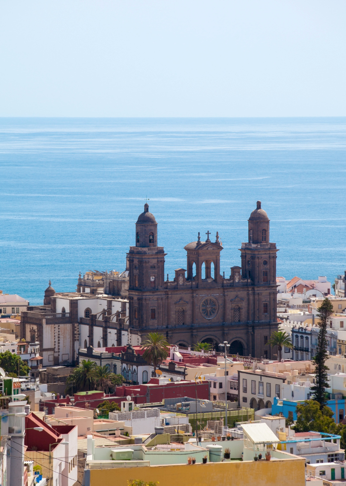 Kathedrale von Las Palmas vor blauem Meer und bunten Häusern.