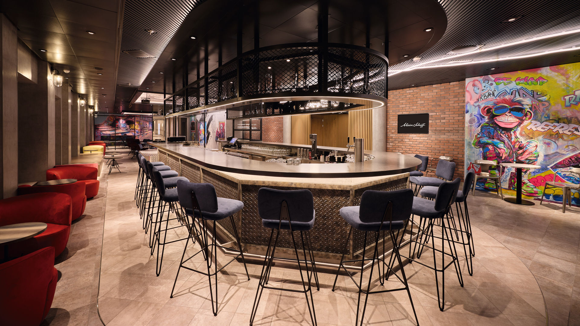 Moderne Bar mit Graffiti-Wand, blauen Stühlen und rotem Sofa.