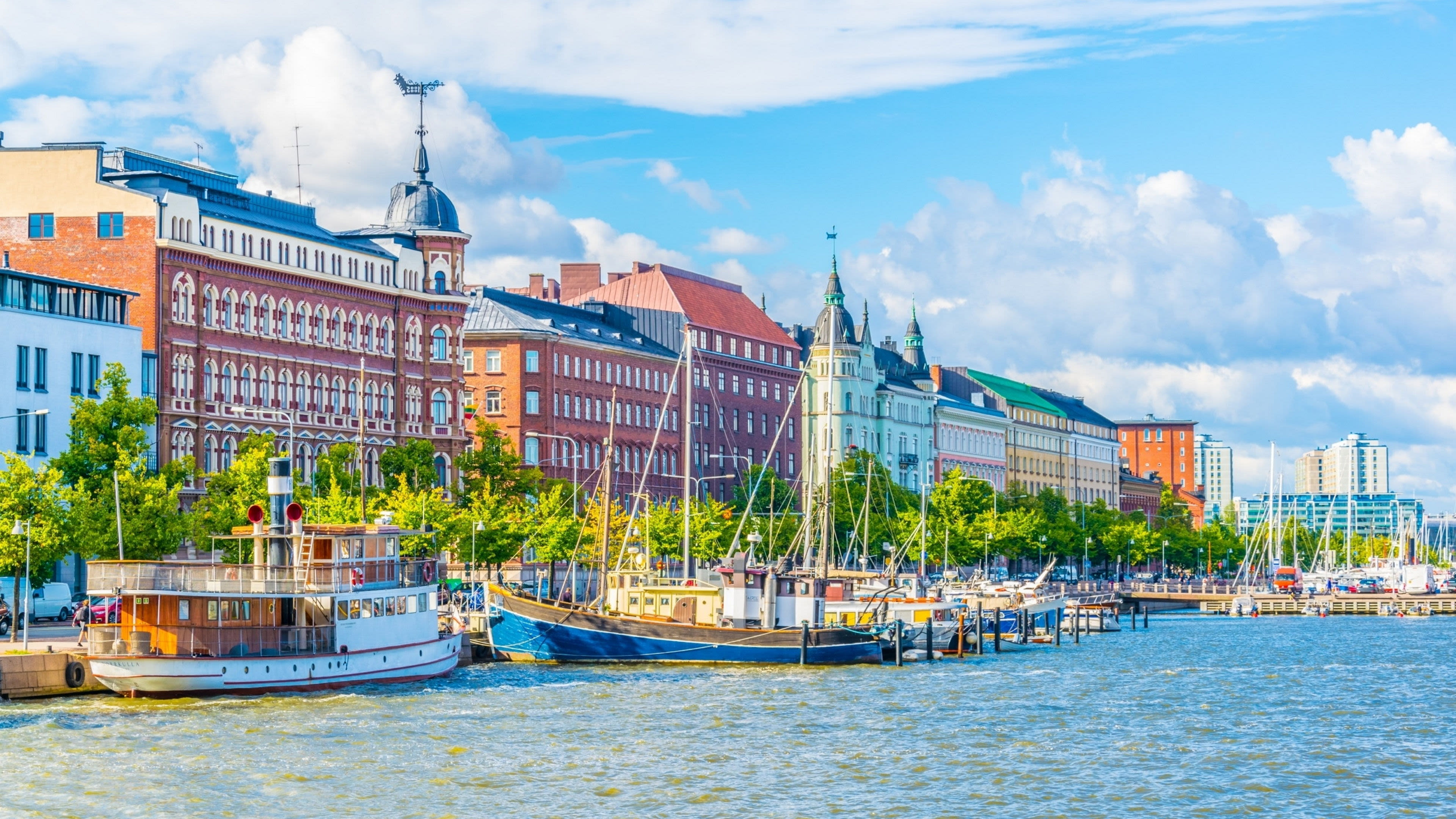 Helsinki Küste mit bunten Gebäuden und Booten im Hafen.