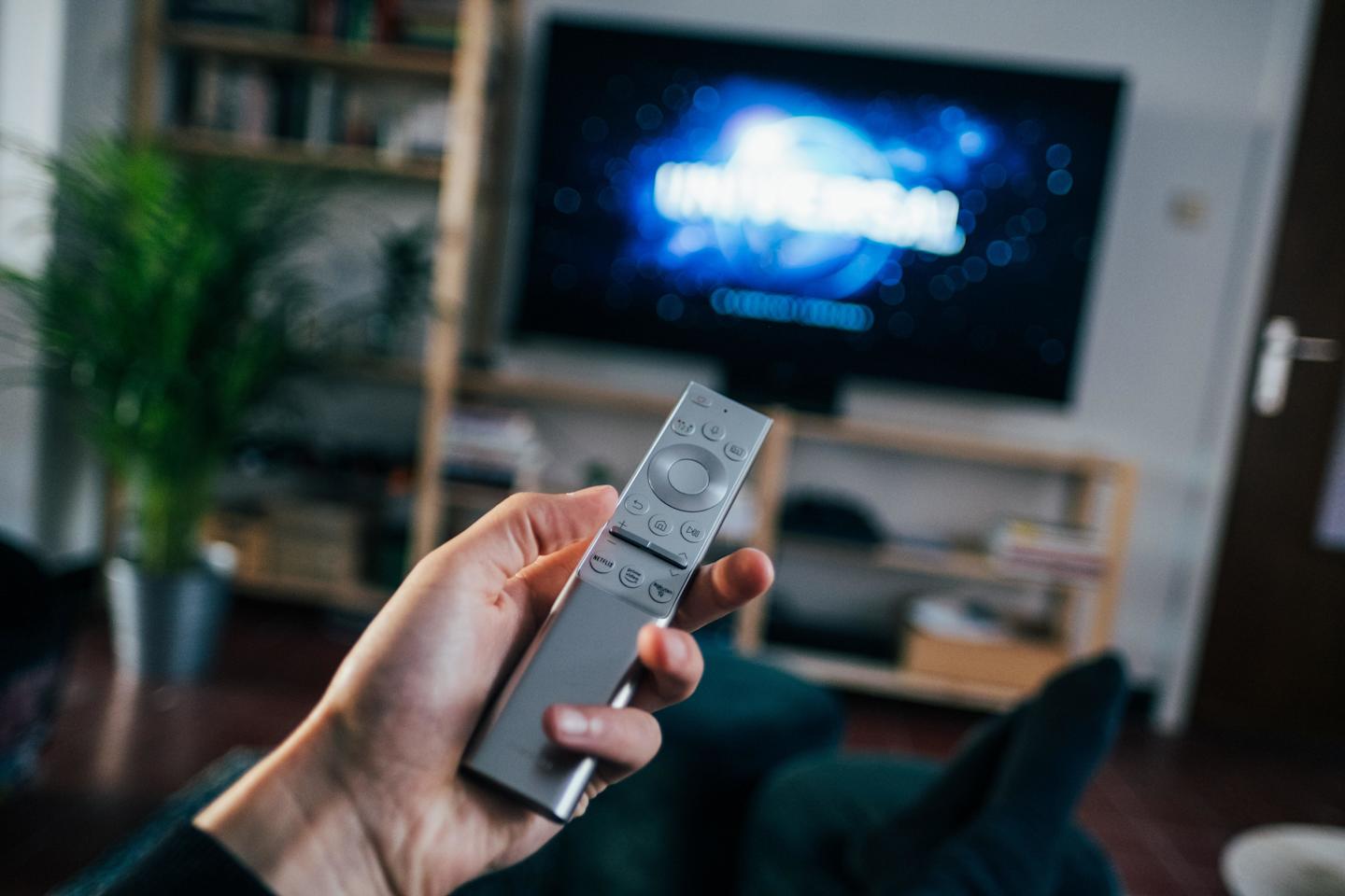 person holding a TV remote
