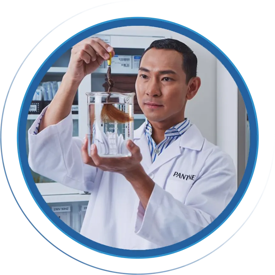 Scientist in laboratory holding a strand of hair