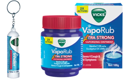 A Vicks Inhaler with a keychain on it and a jar of Vicks VapoRub Extra Strong with its packaging box.