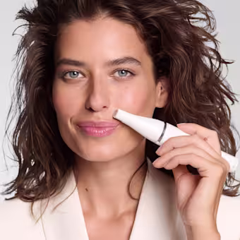 Femmes enlevant les poils de la lèvre supérieure avec l'épilateur facial Braun