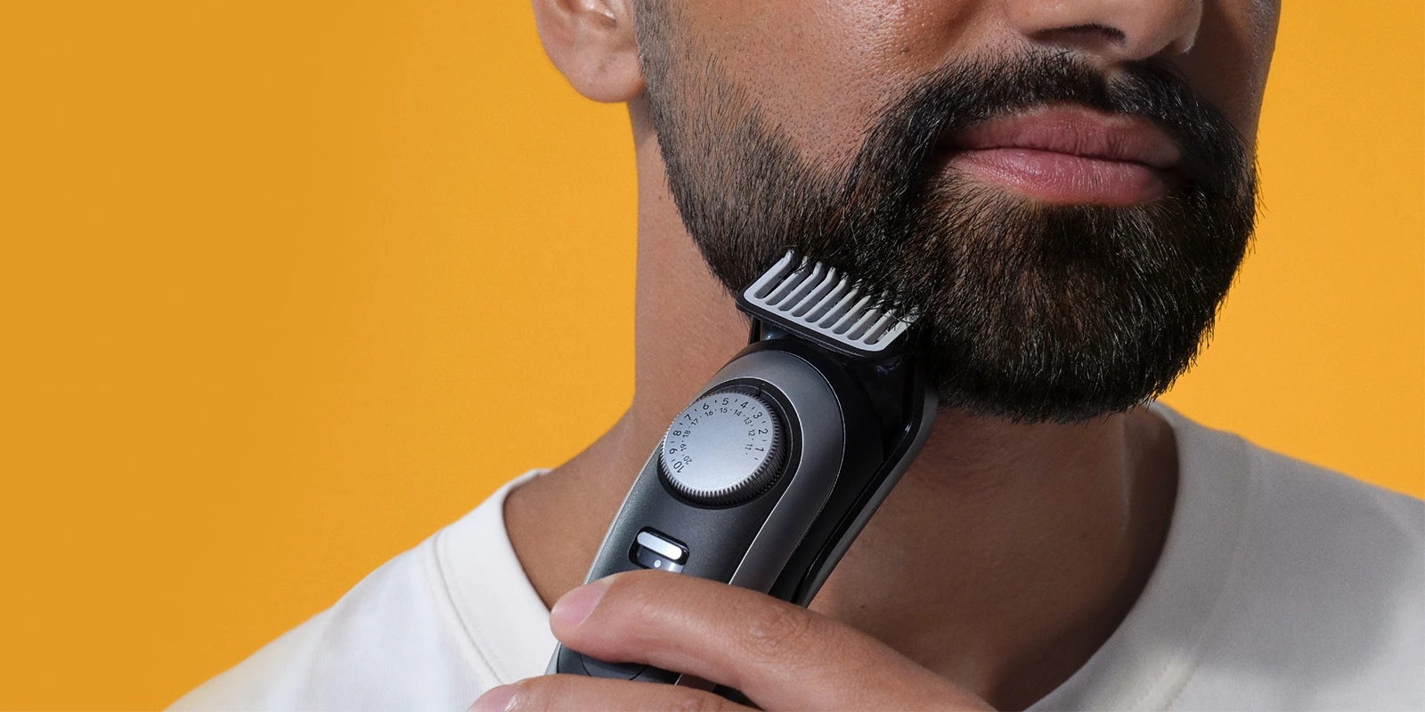 Un homme utilisant une tondeuse à barbe sur sa barbe