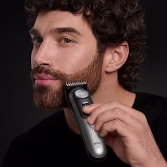 Homme coupant la barbe avec la tondeuse à barbe professionnelle Braun