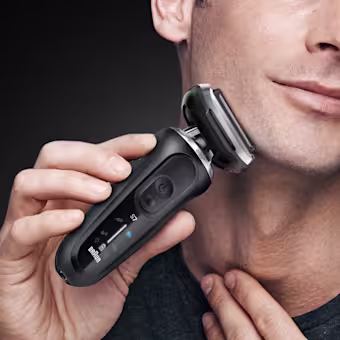 Homme rasant la barbe avec le rasoir électrique Braun