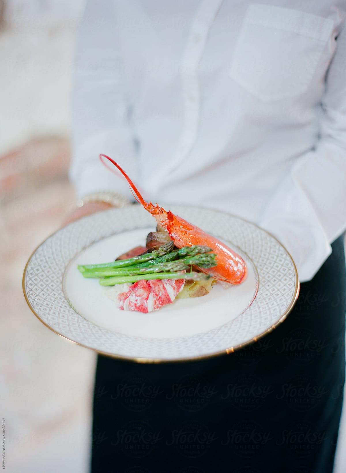 A waiter with a plate of seafood.