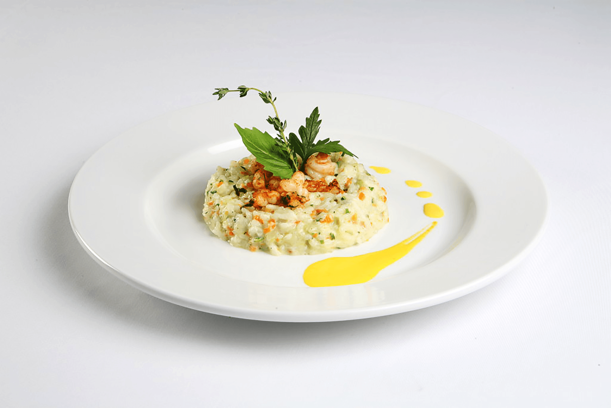 A plate of food with yellow coulis.