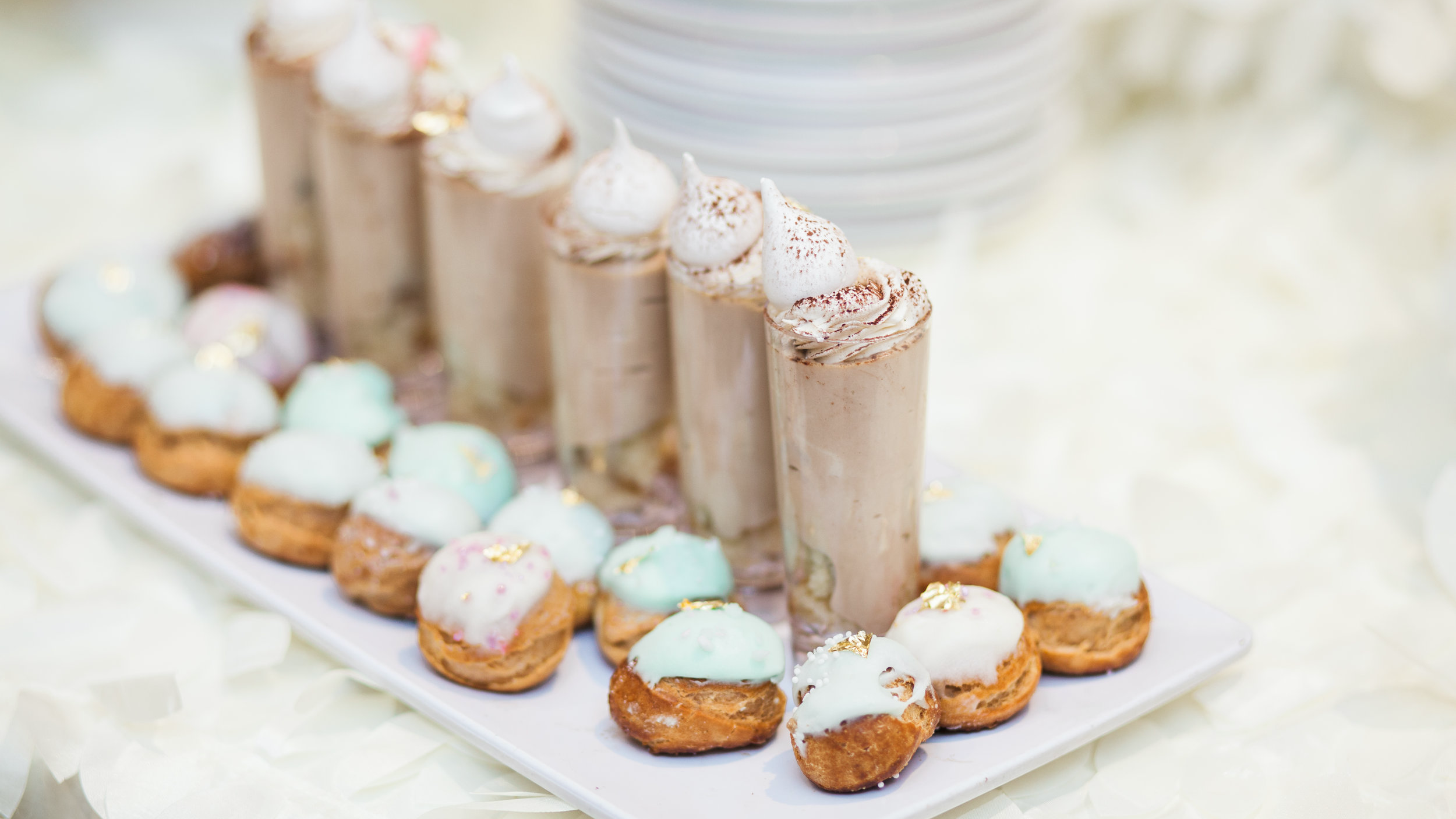 A row of chocolate funnel desserts with round pastries surrounding them.