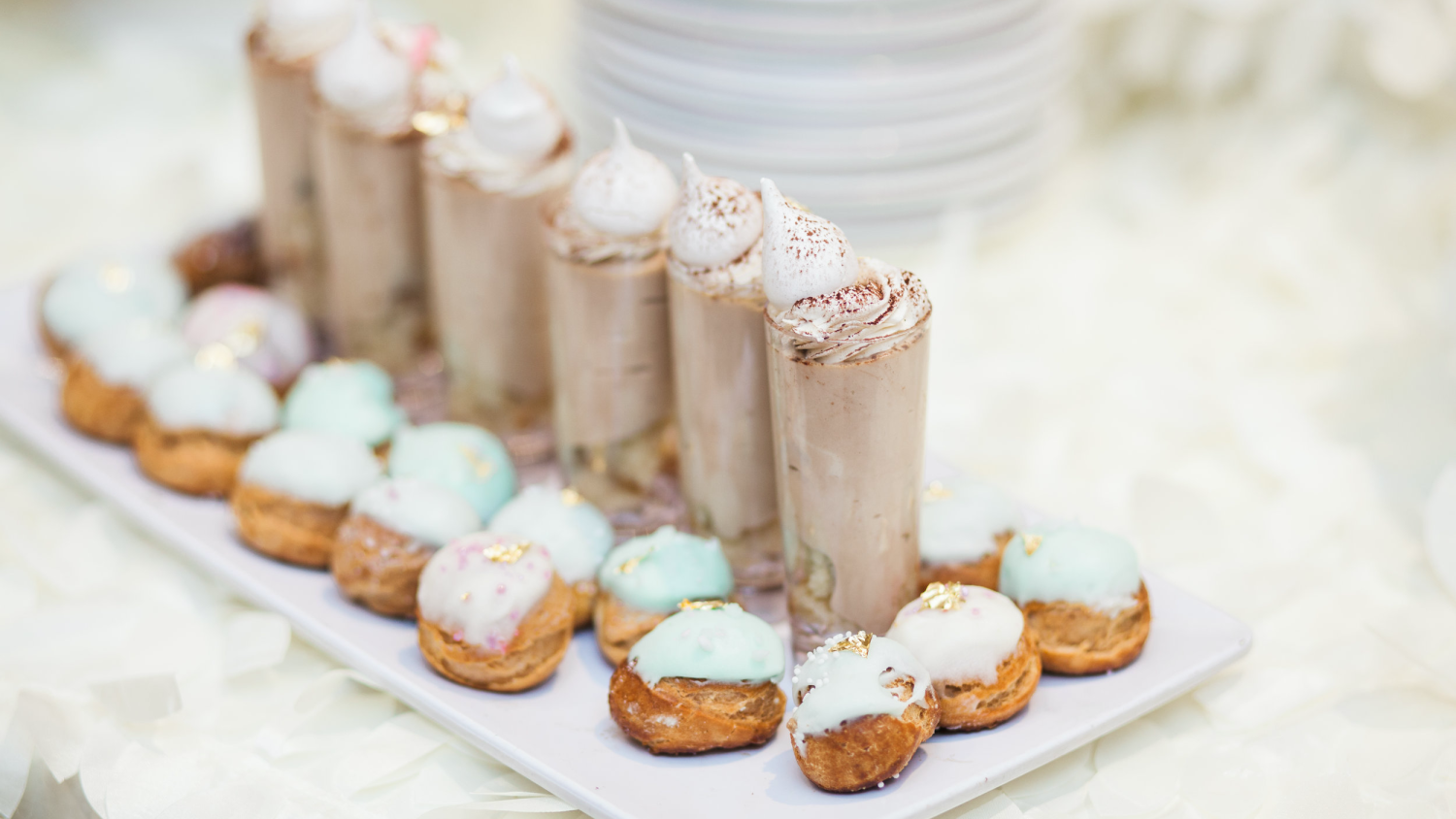 A row of chocolate funnel desserts with round pastries surrounding them.