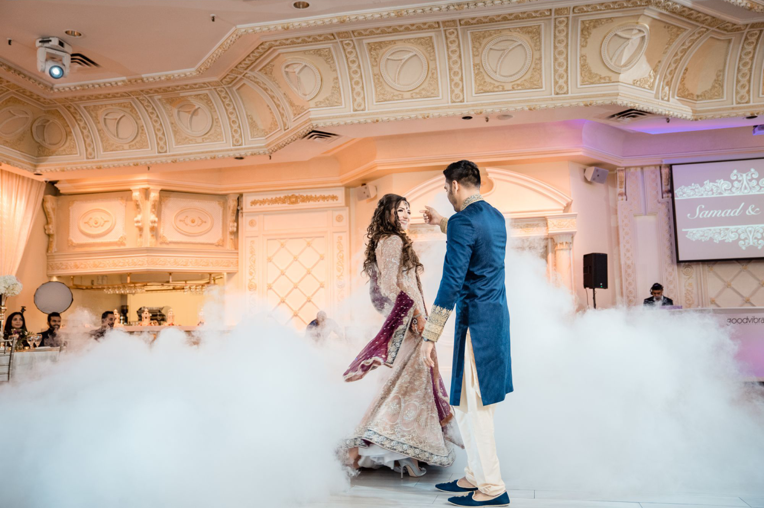 A wedding couple dancing while surrounded by smoke from dry ice. Taken by M+M Photography from Dina + Sam's wedding photos. Attribution: https://www.mandmphotography.ca/2018/10/dina-sam-liberty-grand-paradise-banquet-hall-wedding-toronto-vaughan/