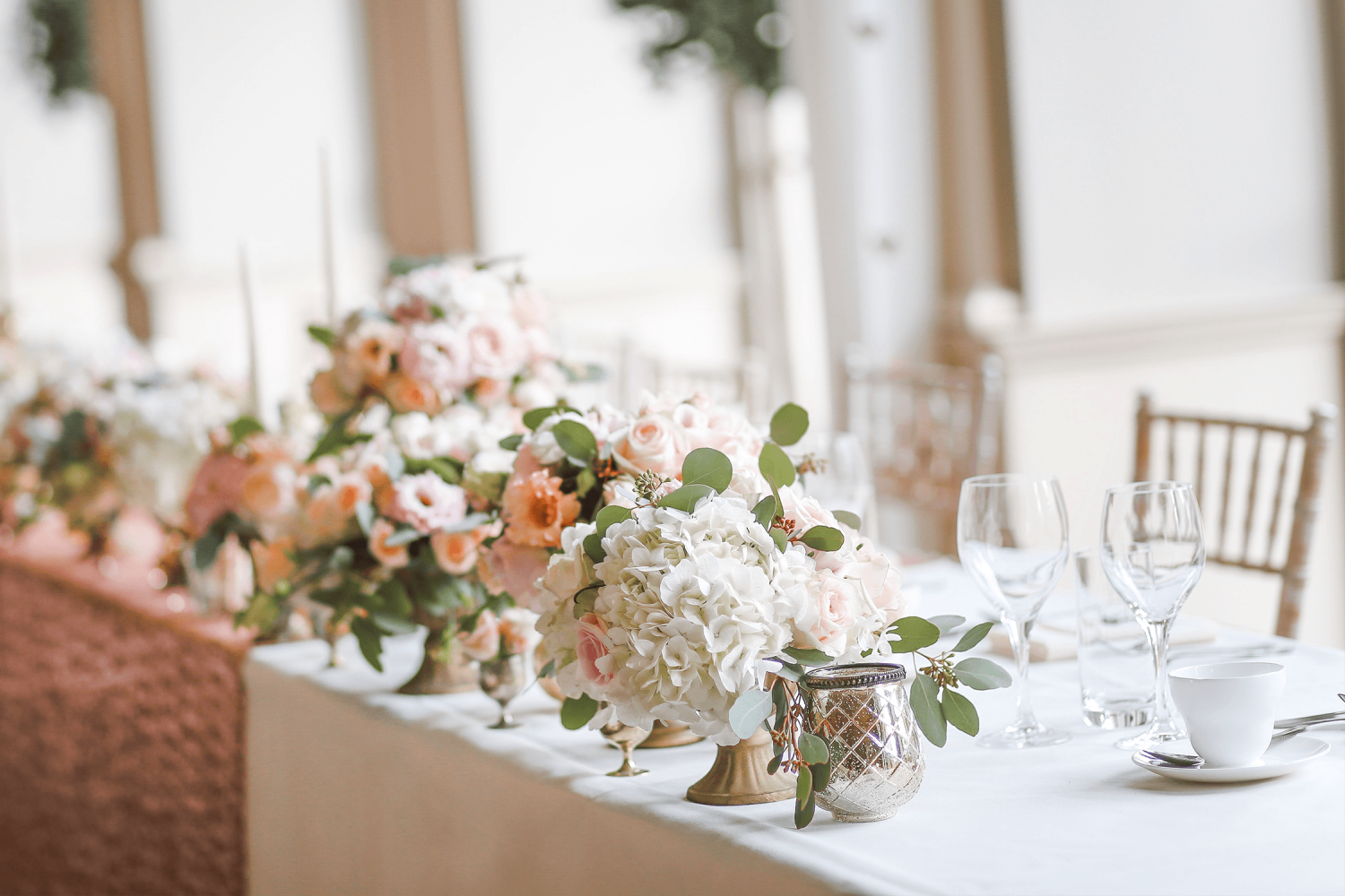 The head table at a wedding with white and pink flowers