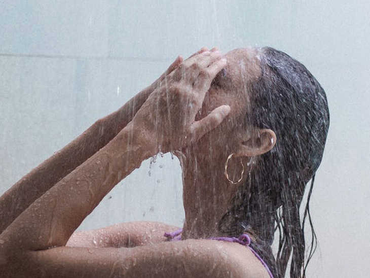 Frau unter der Dusche wäscht sich den Kopf