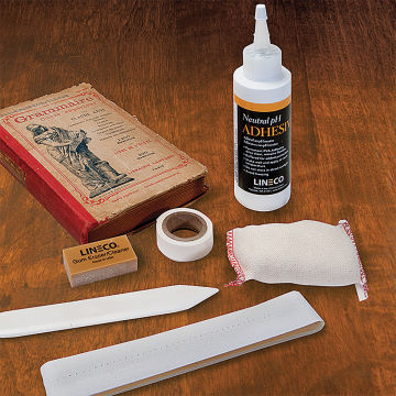 Lineco Book Repair Kit - Components of kit shown with book on table
