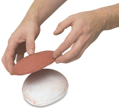Amaco Drape Molds - Hands removing clay from a round mold