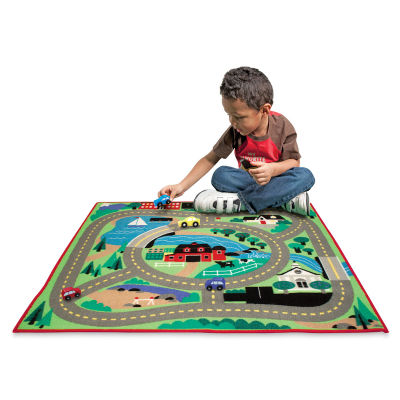 Melissa & Doug Activity Rugs - Boy playing with Round the Town Rug set
