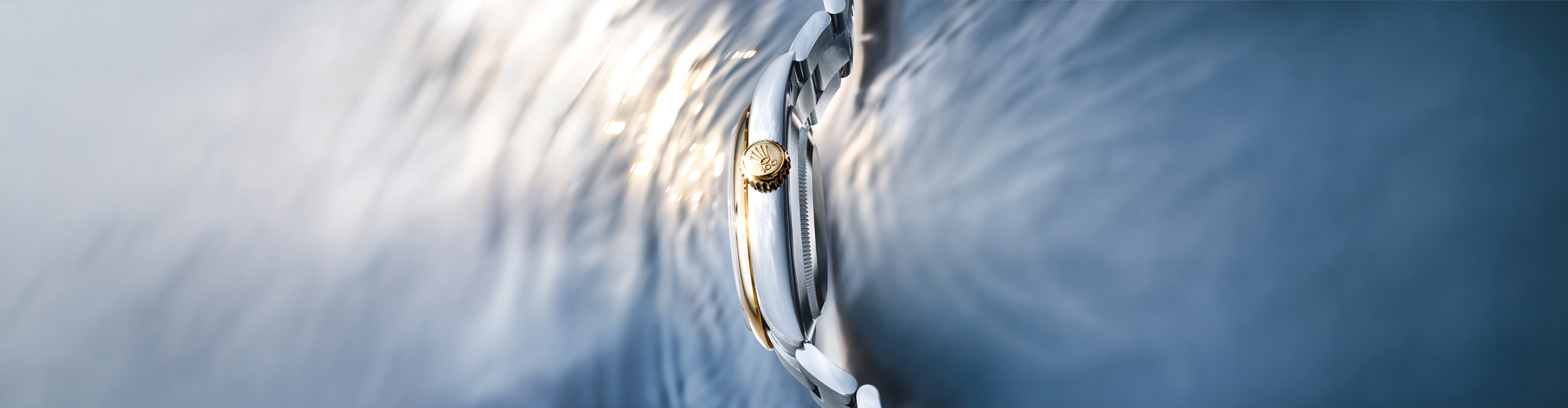 A luxury stainless steel wristwatch with a black dial and silver indices, featuring a metal strap, is set against a gradient teal background. The watch appears modern and sophisticated, showcasing fine craftsmanship.