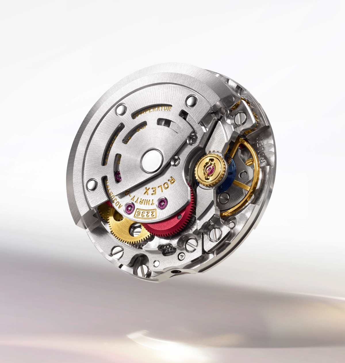 A close-up view of a Rolex watch movement. The intricate mechanical components are visible, including gears, screws, and engravings. The words "Geneva," "Perpetual," "Chronometer," and "Rolex" are adorned on the mechanism in gold lettering.