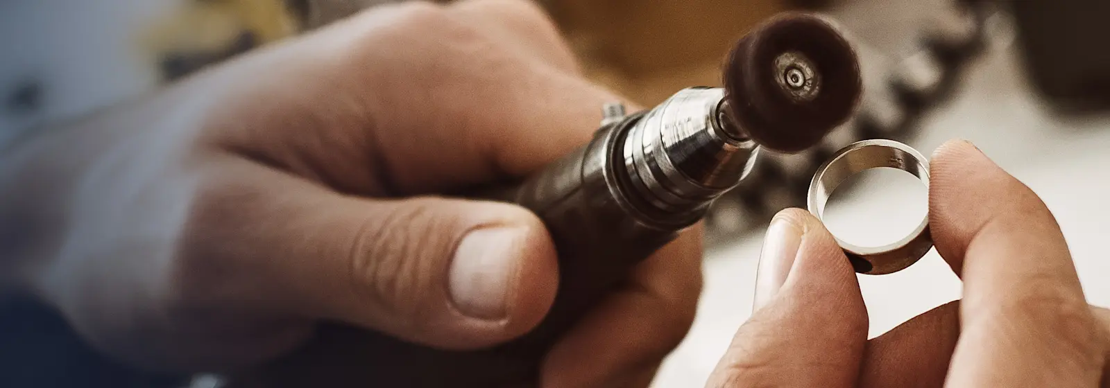 A jeweller carefully polishing a ring