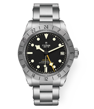 A stainless steel Tudor wristwatch featuring a black dial with luminescent hour markers and hands, a date window at the 3 o'clock position, and a unidirectional rotating bezel. The watch is on a metal link bracelet.