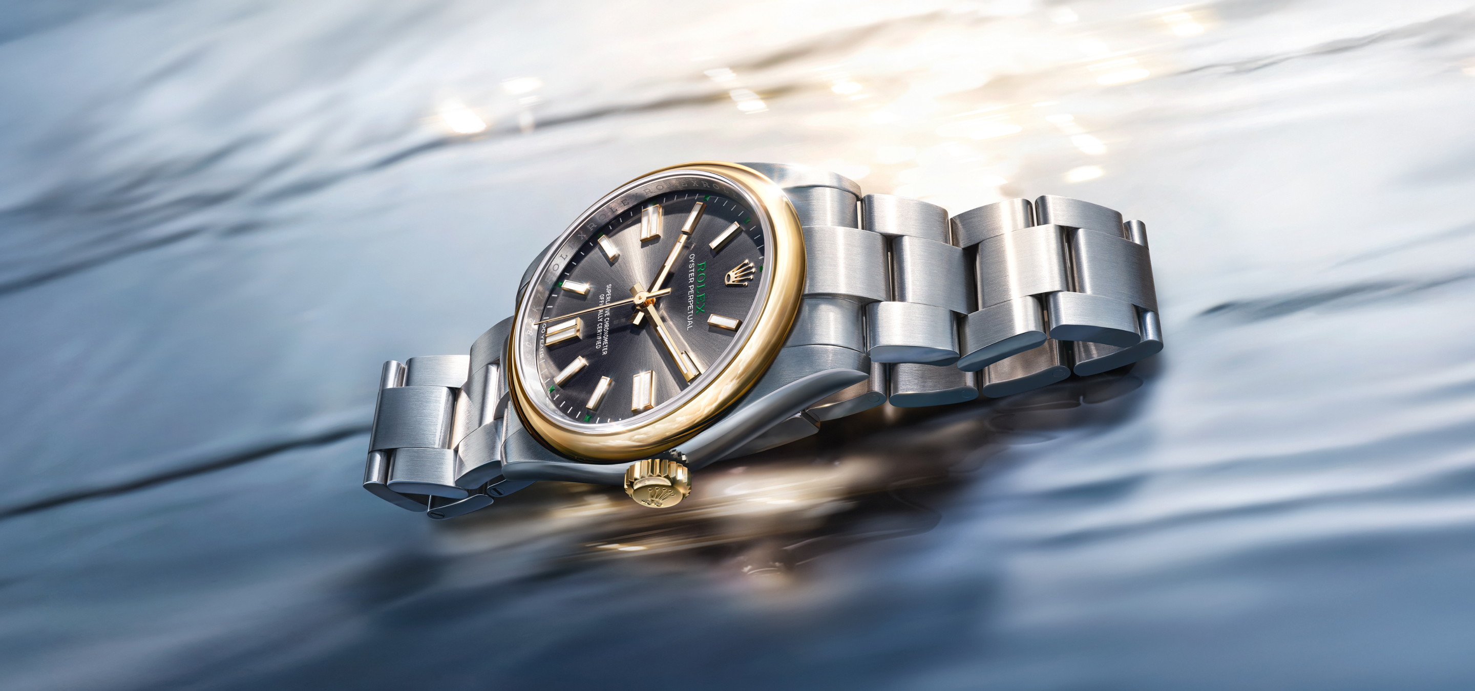 A luxury wristwatch with a black band and an intricately designed silver face featuring multiple dials floats against a soft gradient background transitioning from pale blue to light gold. Light flares subtly in the bottom right corner.