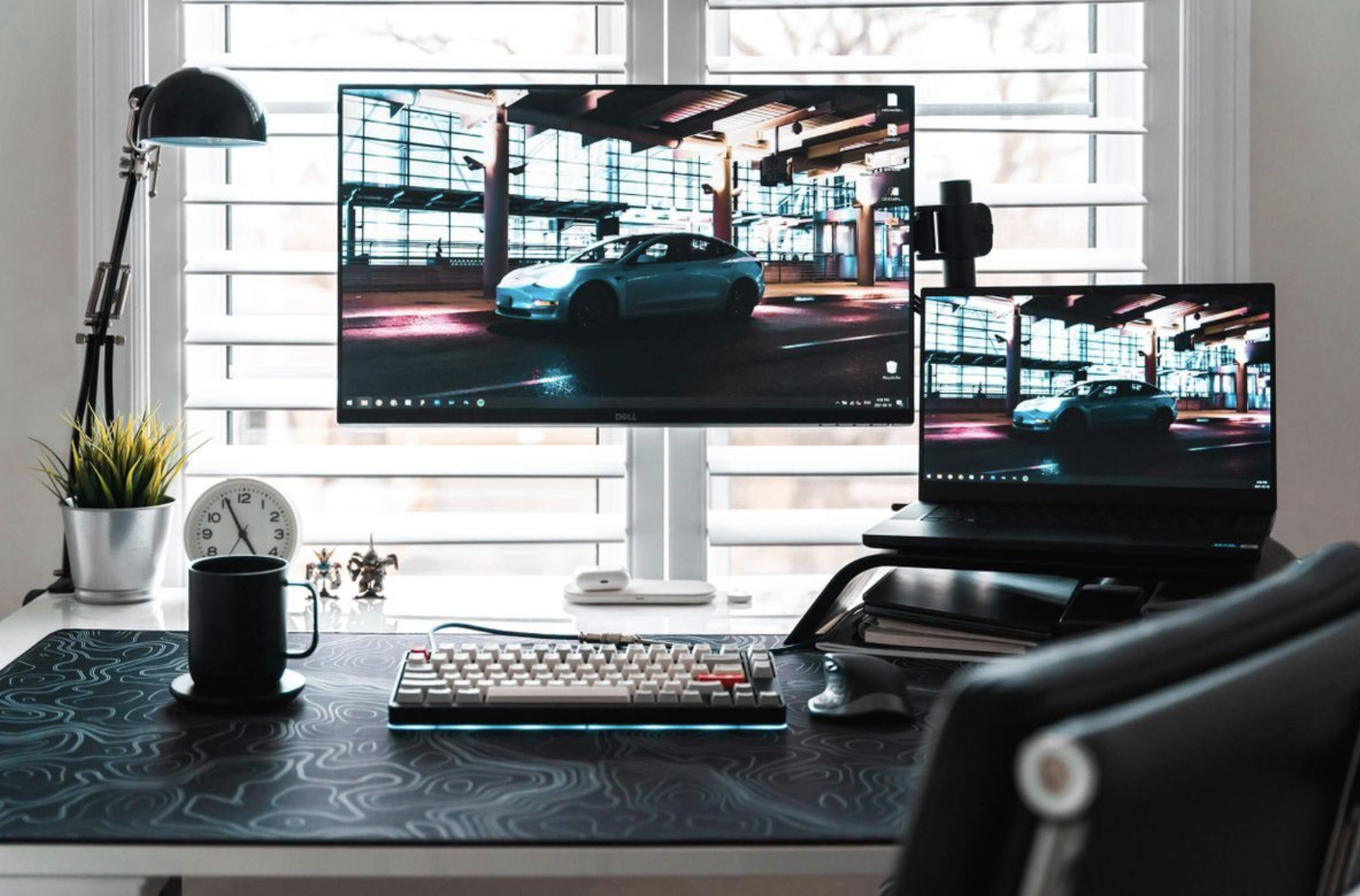 A beautiful desk setup with one monitor and a macbook.