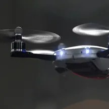 Picture of drone flying in a dark environment with two lights on the side of the drone.